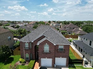 New asphalt shingle roof installation on two-story brick home in McAllen, TX by XYZ Roofing and Restorations.