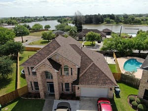 Roofing contractor installing new roof on brick house in Brownsville, TX — XYZ Roofing and Restorations.