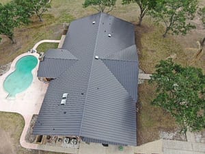 Dark metal residential roof replacement near Corpus Christi, TX — durable hurricane-resistant design.